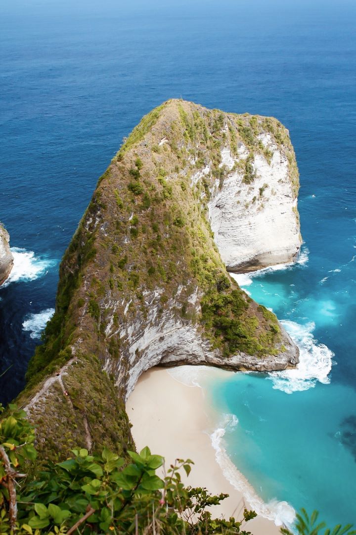 ruta por indonesia vistas desde arriba de playa de arena blanca y montaña en forma de cabeza de dinosaurio